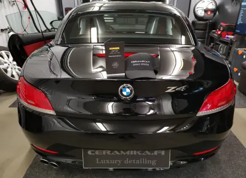 Mustan BMW Z4:n takaluukulla Korrek Pro -pinnoitepakkauksia