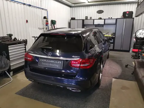 Sininen Mercedes-Benz farmari takaviistosta