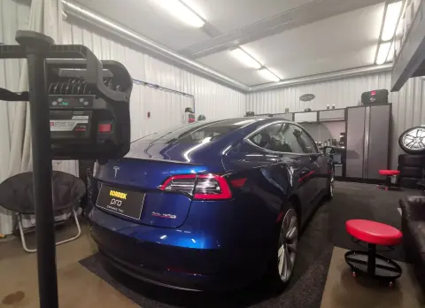 Sininen Tesla takaviistosta hallin valaistuksessa